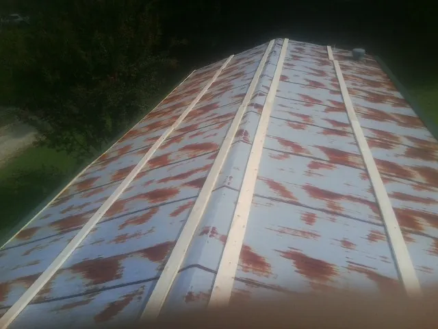Rusted metal roof panels with new wood purlins before replacement — Storm Damage Roof Repair in Ramona by Roofing Brothers