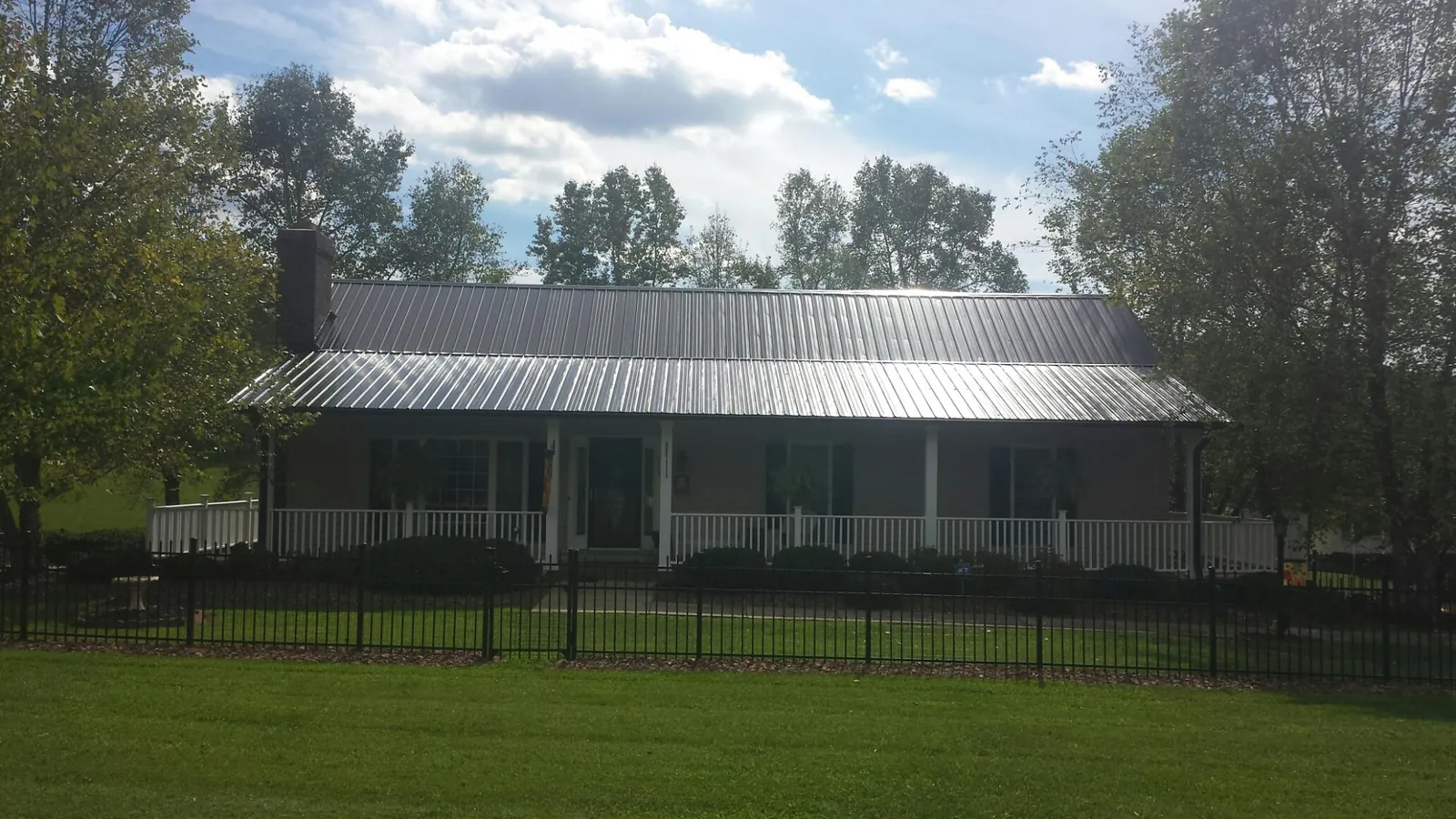 Gray metal roof on a brick ranch with a full width front porch — Gutter Guard Installation work by our crew in Ramona